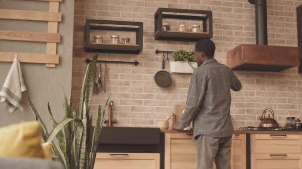 Tracking Slowmo Shot Young African American Man Watering Potted Home — Stock Video