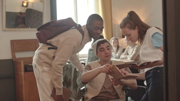 Średnie Powolne Ujęcie Grupy Młodych Wielonarodowych Studentów Pomagających Koledze Niepełnosprawnemu — Wideo stockowe
