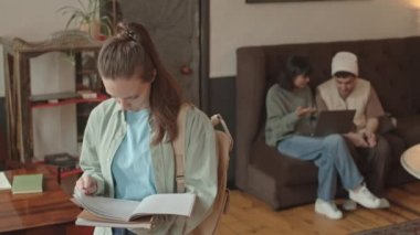 Utangaç beyaz kadın üniversite öğrencisinin belden aşağı vuruşları. Kitap sayfalarını çeviriyorlar. Sonra da modern kampüste gülümseyen kameraya bakıyorlar.