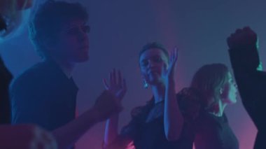 Yirmili yaşlarda, neon ışıkları altında partilere giden şık ve çeşitli insanların yavaşladığı bir ortam.