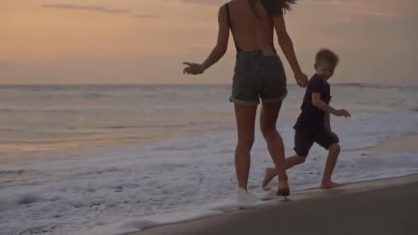Követés Lövés Boldog Anya Kisfia Játszik Strandon Naplementekor Futás Hullámok — Stock videók