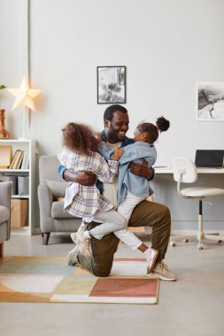 Çocuklar evde babalarıyla eğleniyor.