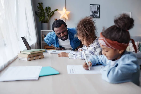 Padre aiutare i bambini con i compiti — Foto Stock