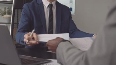 Tanımlanamayan iki erkek meslektaşın resmi takım elbiseler giyip sabahları büroda oturmaları, belgeleri okumaları, çalışmaları...