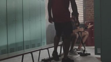 Boks kulübünde antrenman yapmadan önce soyunma odasında el ele tutuşan iki Afro-Amerikan boksörün yavaş çekimi.