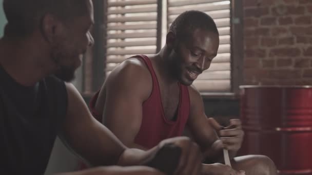 两名年轻而强壮的非洲裔美国拳击手在拳击俱乐部更衣室拉手时说话的慢镜头 — 图库视频影像