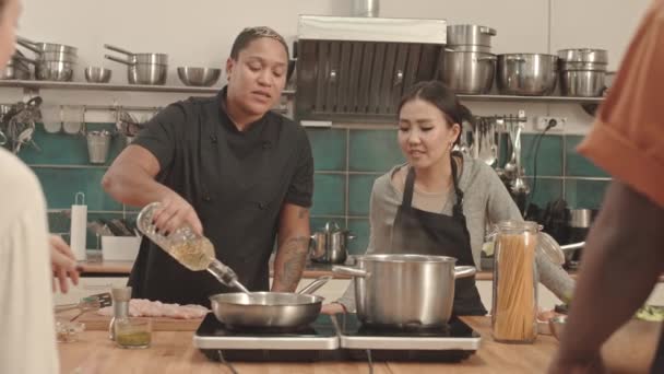 Medium Van Vrouwelijke Afro Amerikaanse Chef Kok Gieten Olie Hete — Stockvideo
