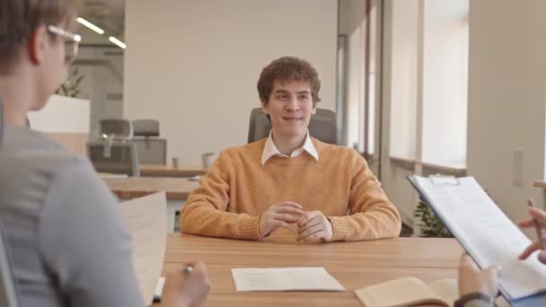 Снимок Улыбающегося Молодого Человека Сидящего Столом Перед Менеджерами Работодателями Смотрящего — стоковое видео