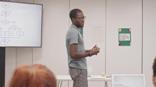 Seguimiento Joven Negro Con Anteojos Enseñando Informática Estudiantes Secundaria Caminando — Vídeo de stock