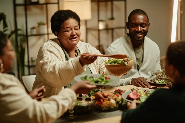 Afrikansk amerikansk mormor serverar mat på middag — Stockfoto