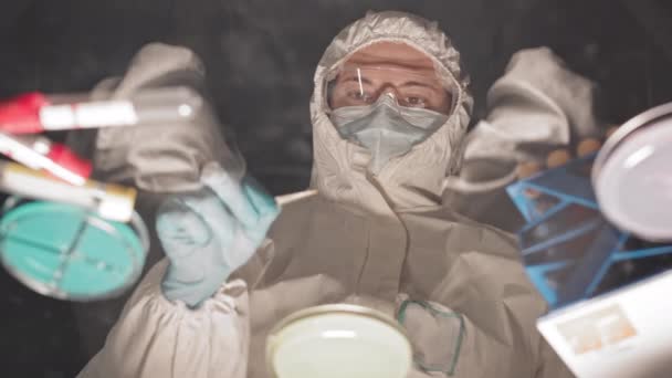 어두운 센터에 페트리 접시와 일하는 과학자의 유리상 위에서 각도로 바라본 — 비디오