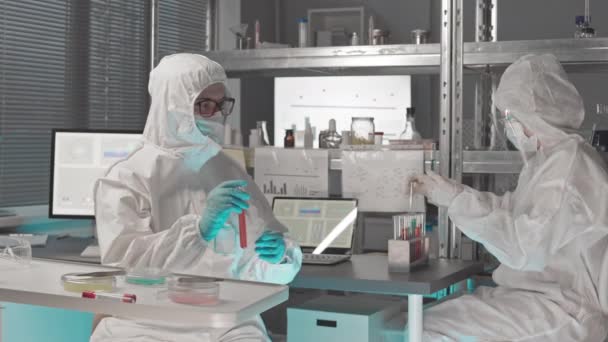 방탄복을 장갑을 의료용 마스크를 책상에 센터에서 물질을 가지고 시험관에서 일하는 — 비디오