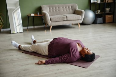 Siyahi Yaşlı Kadın Gevşeme Yogasının tadını çıkarıyor