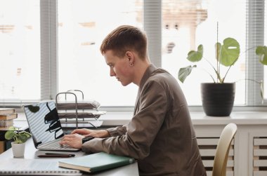 Ofiste dizüstü bilgisayarda çalışan iş adamı.
