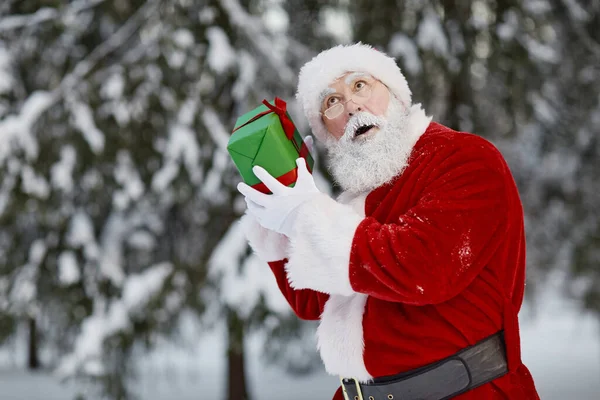 Santa Claus wstrząsające pudełko prezentów — Zdjęcie stockowe