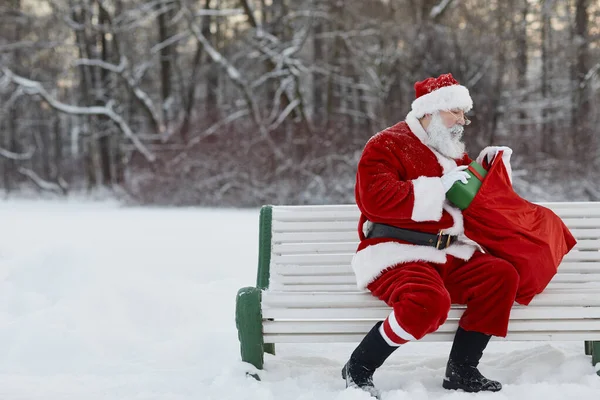 Santa Claus sedí v parku — Stock fotografie