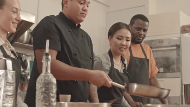 Genç Kadın Aşçının Tavada Fileto Çevirdiği Düşük Açı Asyalı Beyaz — Stok video