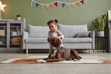 Şirin siyah kız köpekle oynuyor.