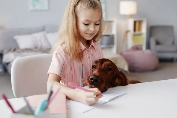 Дівчина робить домашнє завдання з собакою — стокове фото