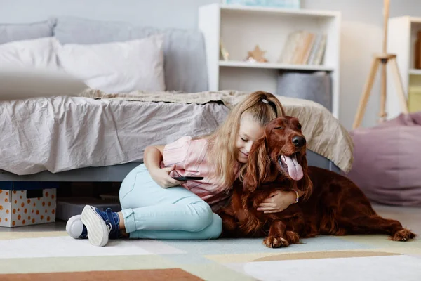 Meisje knuffelen met hond thuis — Stockfoto