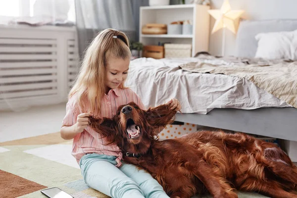 Ο σκύλος παίζει με το κοριτσάκι. — Φωτογραφία Αρχείου