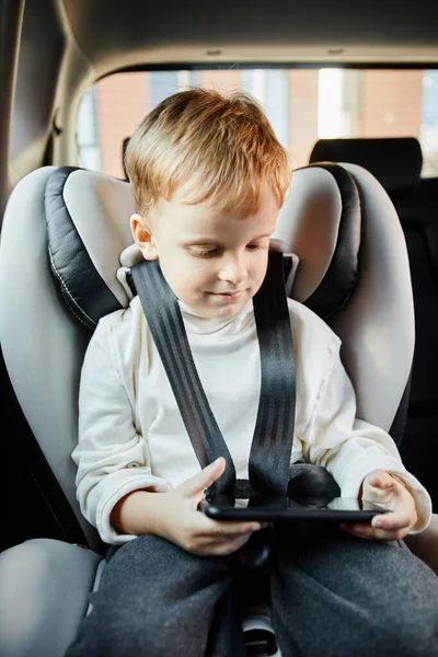 Niño pequeño usando Smartphone en el coche — Foto de Stock