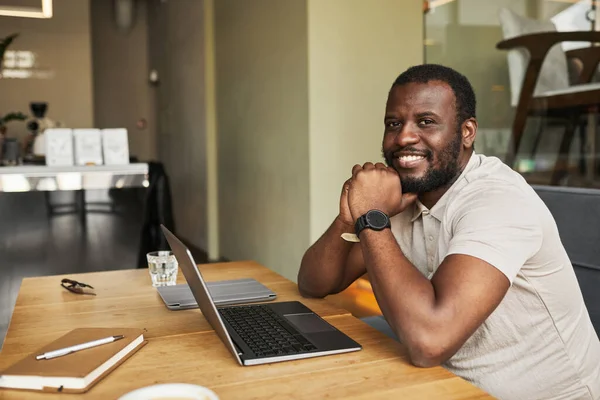 Usmívající se černoch pracující u Cafe Table — Stock fotografie
