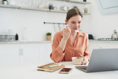 Kadın kahvaltıda çalışıyor.