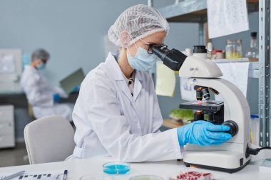 Chemist using microscope at work