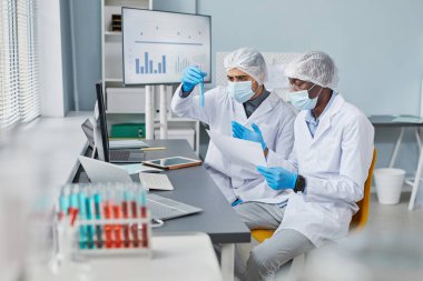Men examining samples in tubes