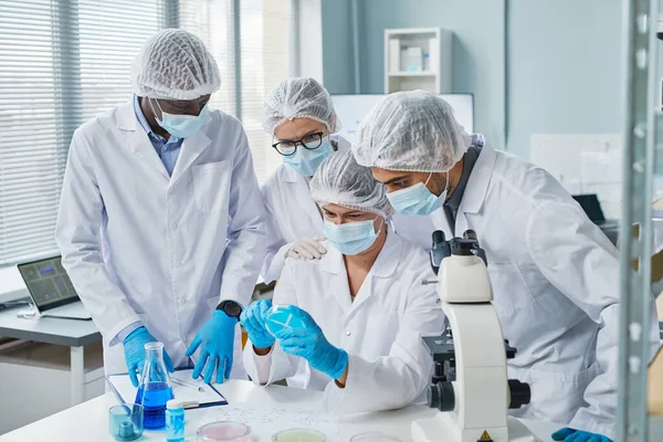 Científicos examinando la muestra en equipo — Foto de Stock