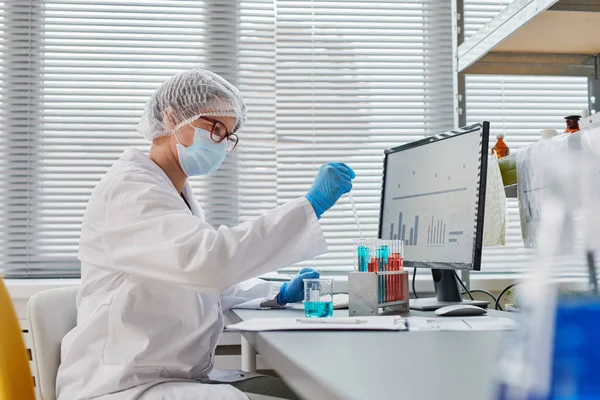 Chemist examining samples in test tubes — Stockfoto