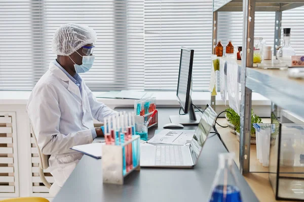 Man examining samples in test tubes — Stockfoto