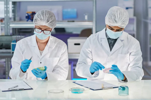 Chemists mixing chemicals in test tubes — Stockfoto