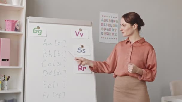 Medium Slowmo Shot Young Female Speech Therapist Teaching Alphabet Standing — Stockvideo