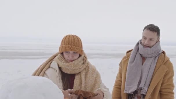 Medium Slowmo Shot Young Romantic Couple Making Snowman Cold Winter — Stockvideo