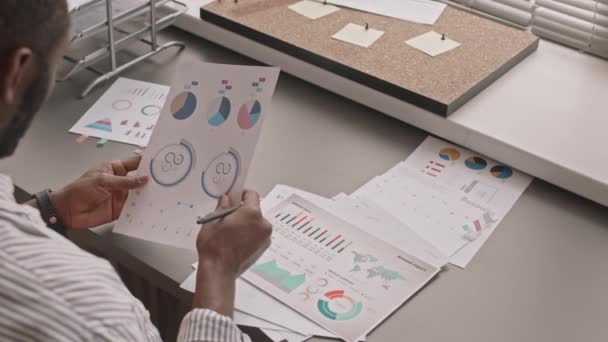 Медленная Фотография Афроамериканского Бизнесмена Просматривающего Финансовые Диаграммы Диаграммы Напечатанные Бумаге — стоковое видео