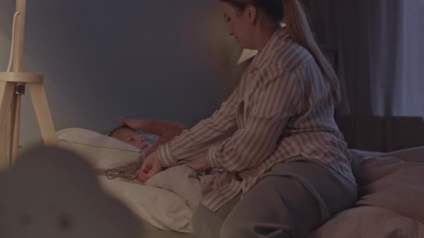 Медленный Снимок Заботливой Матери Укладывающей Свою Маленькую Дочь Спать Снимающей — стоковое видео