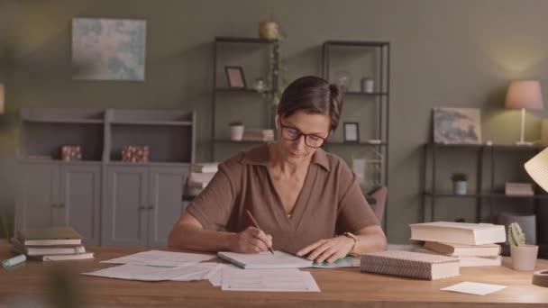 Таліть Повільний Знімок Жінки Середнього Віку Окулярах Роблячи Нотатки Навчаючись — стокове відео