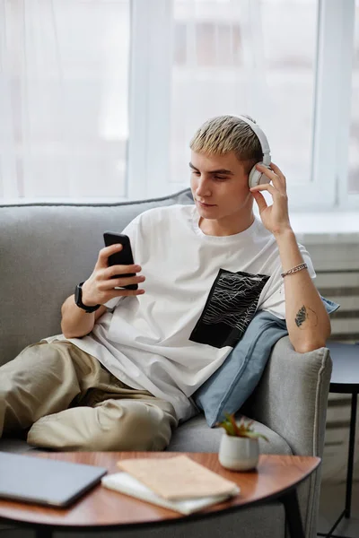 Blond ung man lyssnar på musik — Stockfoto