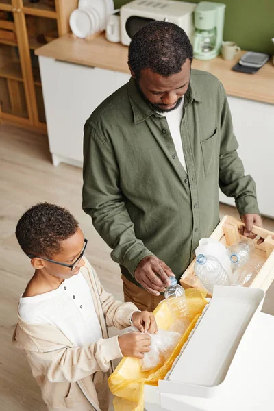 Zwarte vader en zoon sorteren huishoudelijk afval — Stockfoto