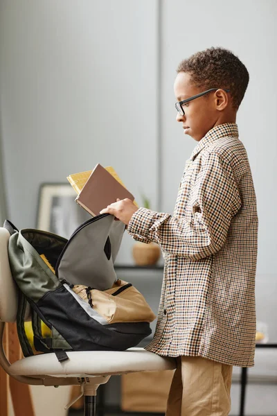 Афроамериканский мальчик упаковывает рюкзак сбоку — стоковое фото
