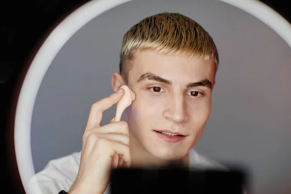 年轻男子在美容影片中使用面部按摩器 — 图库照片