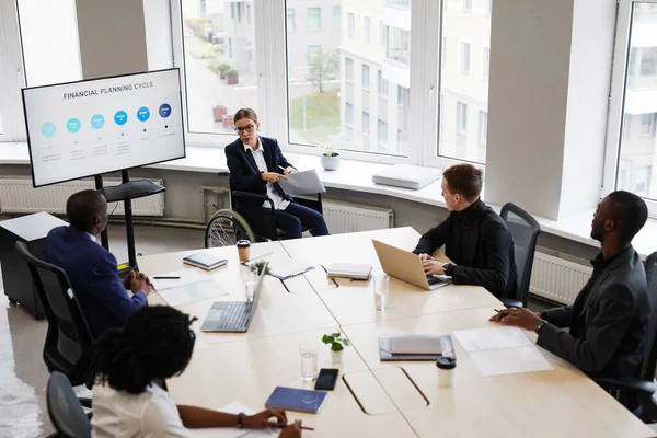 Leader femminile che utilizza sedia a rotelle nella riunione di lavoro — Foto Stock