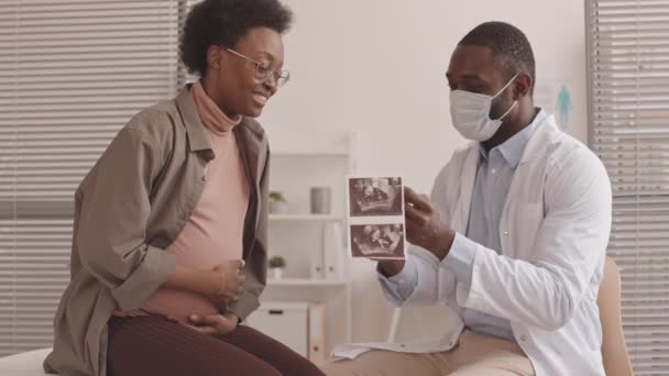 Mittlere Langsamaufnahme Eines Afroamerikanischen Arztes Und Einer Glücklichen Jungen Schwangeren — Stockvideo
