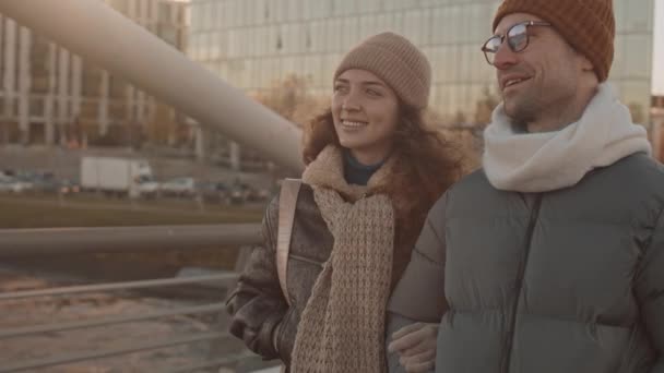 Średnie Powolne Ujęcie Szczęśliwej Młodej Kaukaskiej Pary Spacerującej Wzdłuż Mostu — Wideo stockowe