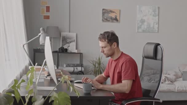 Mediana Slow Shot Hombre Caucásico Joven Escribiendo Teclado Mientras Trabaja — Vídeos de Stock