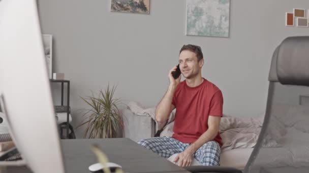 Medium Slowmo Shot Van Jonge Blanke Man Pyjama Praten Smartphone — Stockvideo