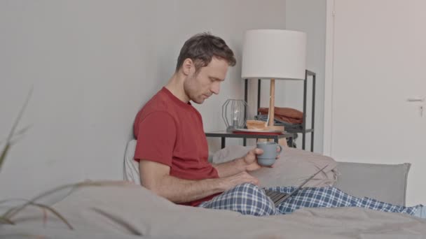 Medium Slowmo Shot Caucasian Male Freelancer Pajamas Working Laptop Bed — Stock Video