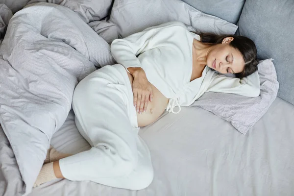 Femme enceinte reposant dans son lit — Photo